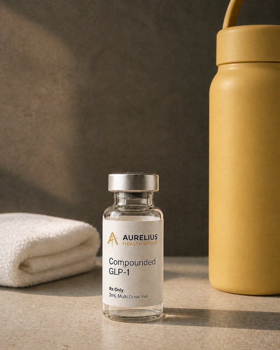 An Aurelius vial on a concrete table beside a towel and a water bottle